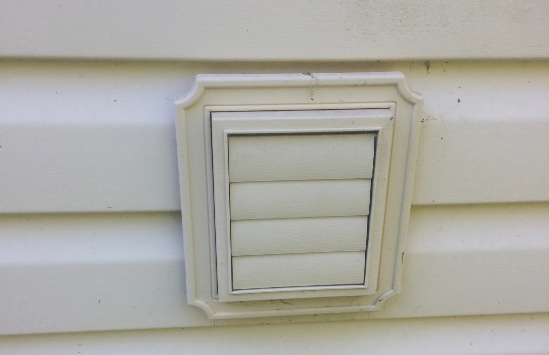Dryer vent fitted through vinyl siding | Nansemond River Roofing & Siding
